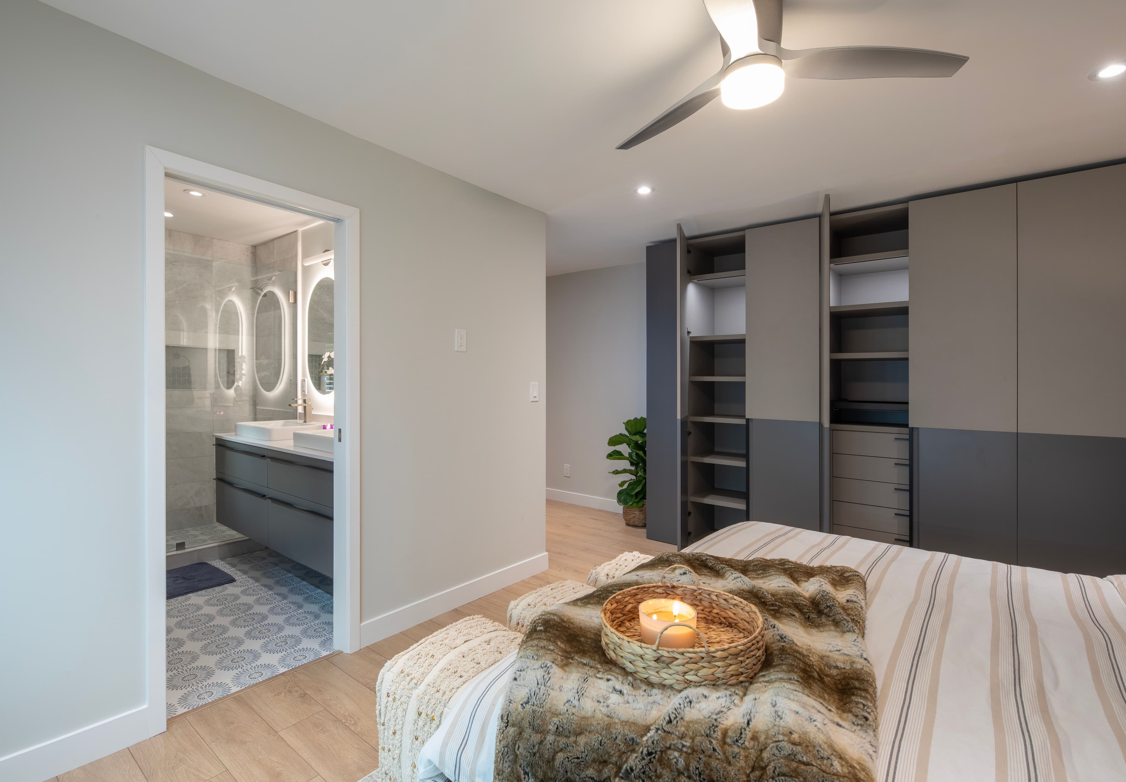 Modern bedroom with custom closets, sleek storage solutions, and an adjacent stylish bathroom, designed by Febal Casa to showcase expert home remodeling and interior design.