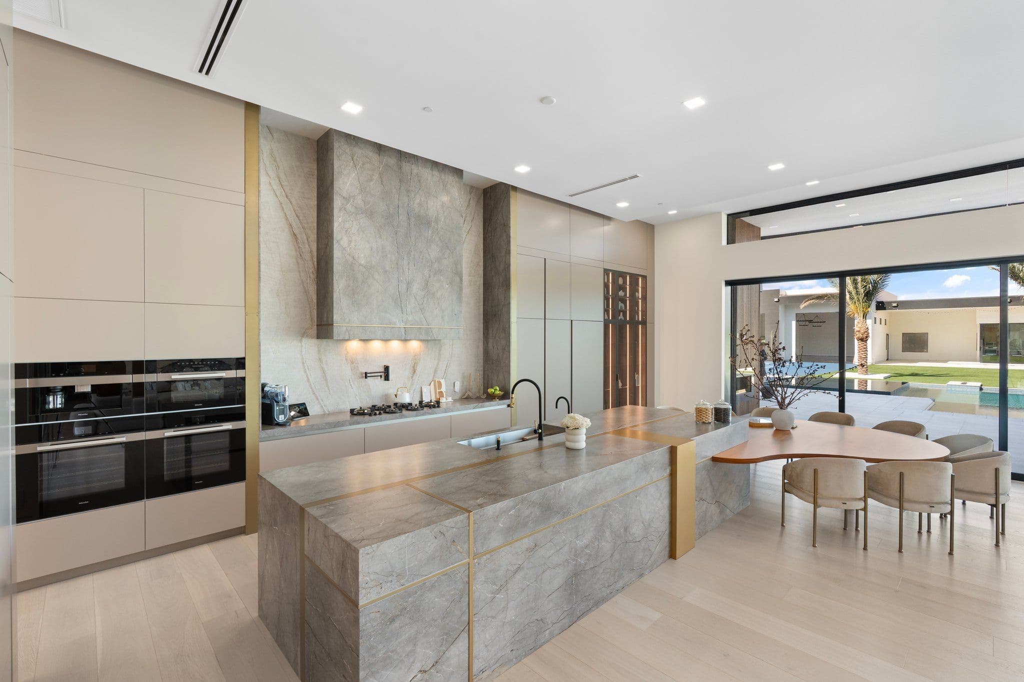 Contemporary kitchen with white cabinetry and sleek countertops, part of the Modern Desert Oasis collection for a luxurious cooking space.