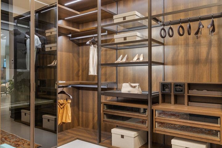 Elegant wooden closet with shelves, drawers, and hanging bars, showcasing an organized and modern design.